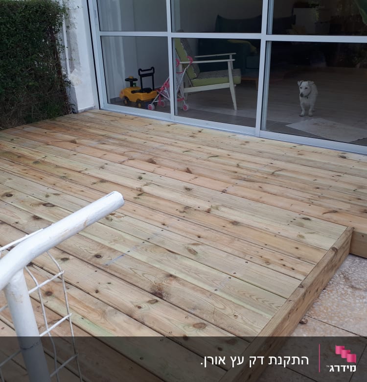 דק עץ חדש ליד חלון זכוכית גדול